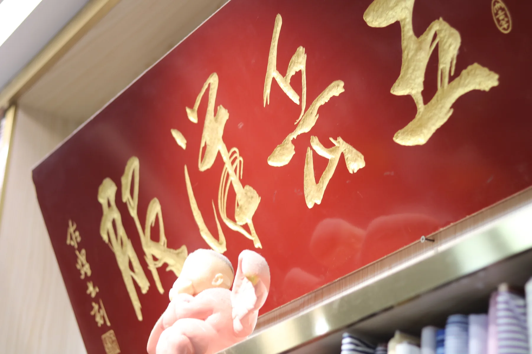 The red and gold 五岳洋服 house sign inside Wuyue